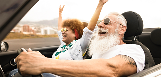 two people riding in a convertible vehicle with the top down