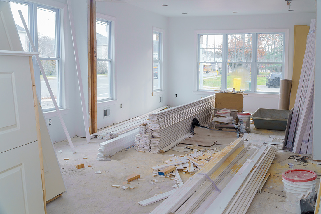 Room of a house clearly under construction gutted and with boards of wood everywhere.