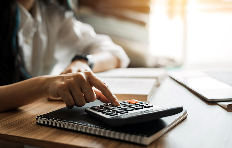 Person sitting at desk crunching numbers on a calculator