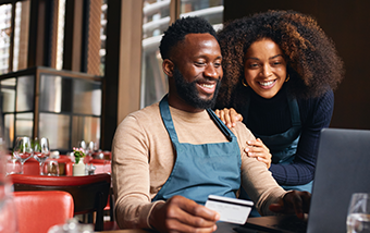 two restaurant owners shopping online with their business credit card