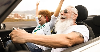 Senior couple driving in a convertable