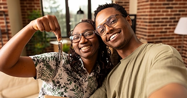 happy young couple celebrating new house keys