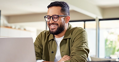 Man looking at his laptop smiling